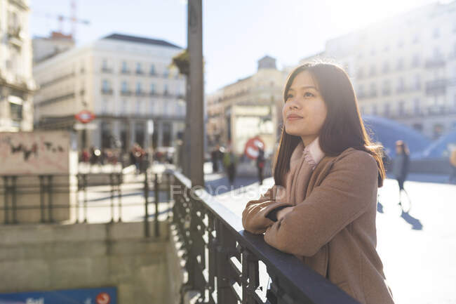 Espanha, Madrid, sorrindo jovem mulher em Puerta del Sol olhando ao redor — Fotografia de Stock