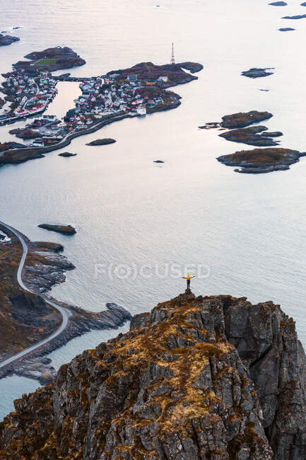 Norvegia, Isole Lofoten, Henningsvaer, uomo in piedi sul punto di vista con le braccia alzate — Foto stock