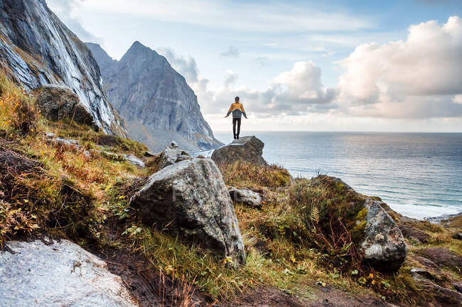 Noruega, Islas Lofoten, excursionista de pie sobre roca - foto de stock