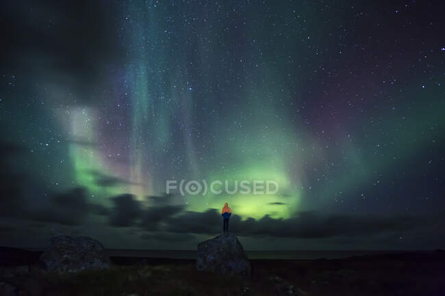 Norvège, îles Lofoten, Eggum, homme debout sur le rocher et regardant les aurores boréales — Photo de stock