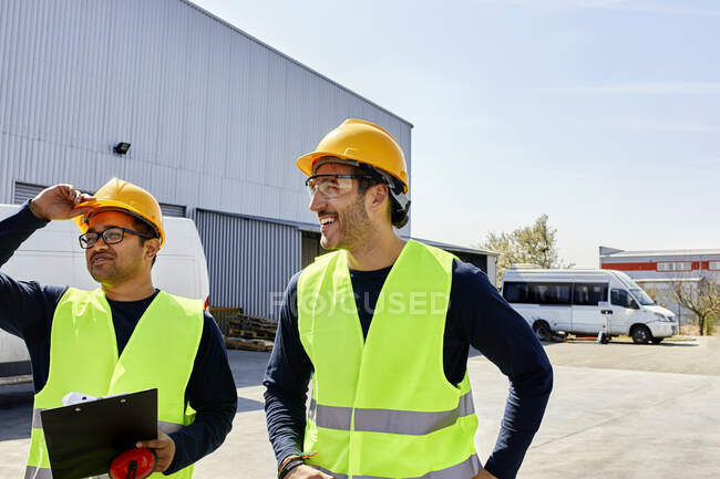 Dois trabalhadores conversando no pátio da fábrica — Fotografia de Stock