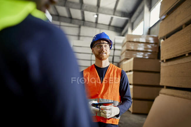 Travailleur dans un entrepôt d'usine tenant la tablette — Photo de stock