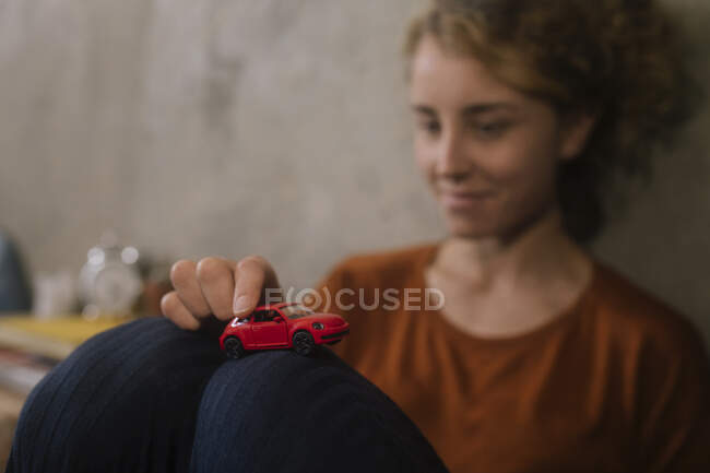 Young woman playing with red toy car — Stock Photo