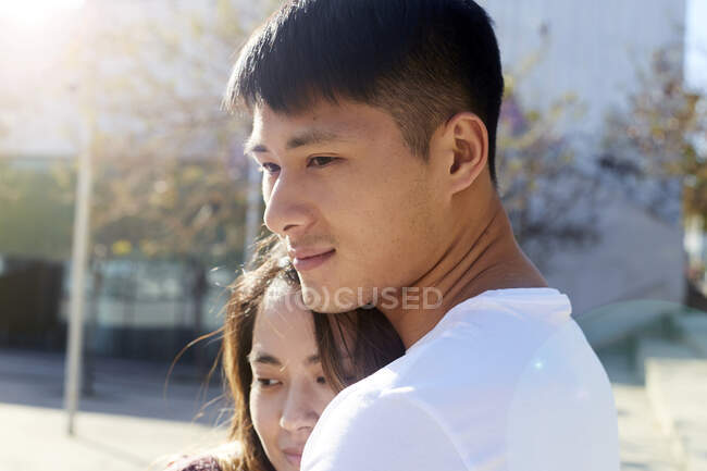 Щаслива молода пара обіймає на відкритому повітрі на заході сонця — стокове фото