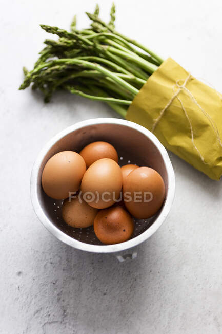 Спаржа и яйца на столе, вид спереди — стоковое фото