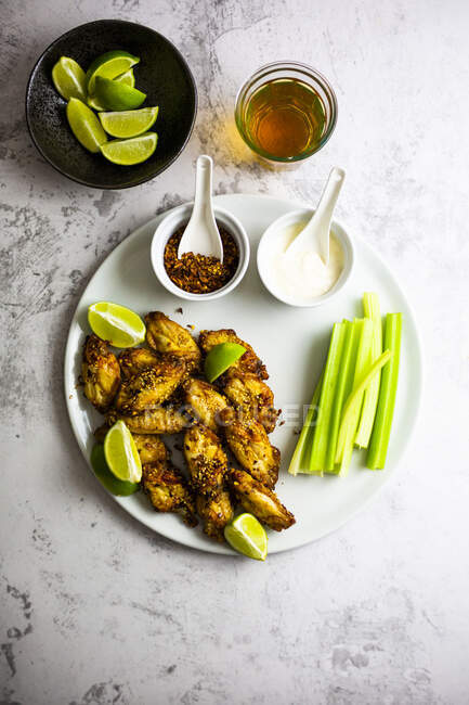 Spicy chicken wings with lime and celery — Stock Photo