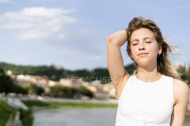 Retrato de mulher jovem com os olhos fechados apreciando a brisa — Fotografia de Stock