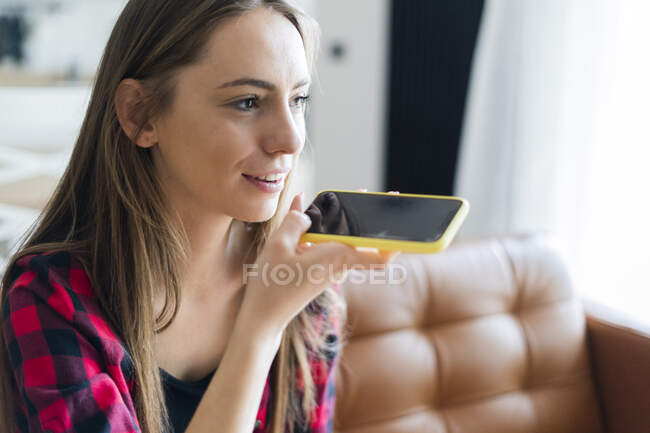 Mujer joven usando el teléfono celular en casa - foto de stock