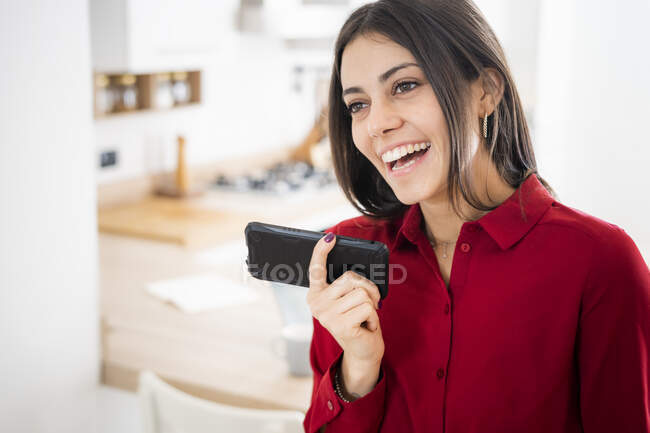 Felice giovane donna d'affari utilizzando smartphone a casa — Foto stock