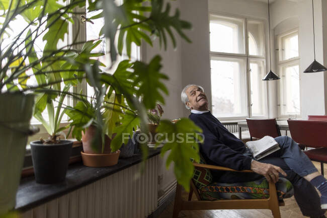 Uomo anziano seduto sulla sedia a casa — Foto stock