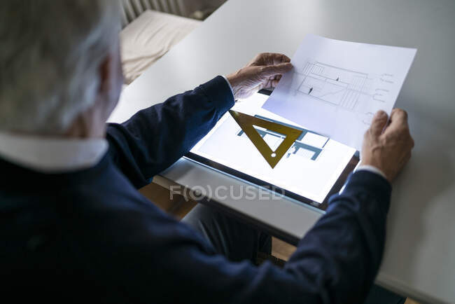 Senior man using tablet with architectural plan — Stock Photo