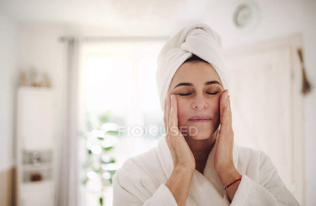 Ritratto di donna matura in un bagno a casa applicando idratante — Foto stock