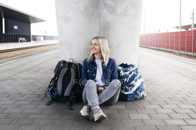 Femme souriante qui attend au quai de la gare — Photo de stock