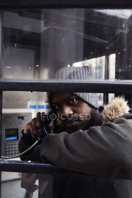 Uomo adulto medio che utilizza una cabina telefonica — Foto stock