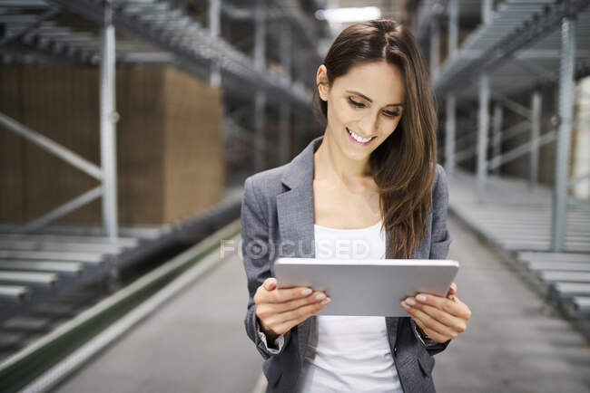 Улыбающаяся деловая женщина с планшетом на заводе — стоковое фото