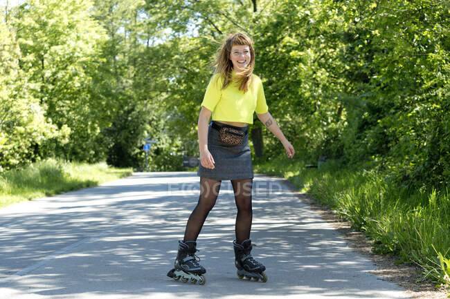 Porträt einer lachenden jungen Frau mit Inlineskates — Stockfoto