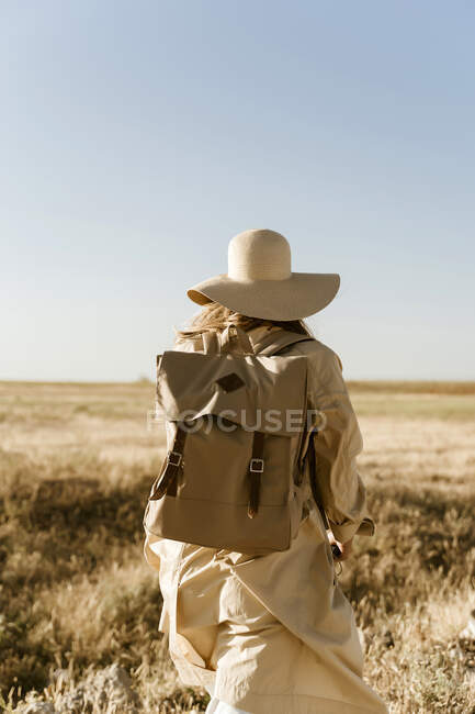 Rückansicht einer Reisenden mit Rucksack auf Wiese — Stockfoto