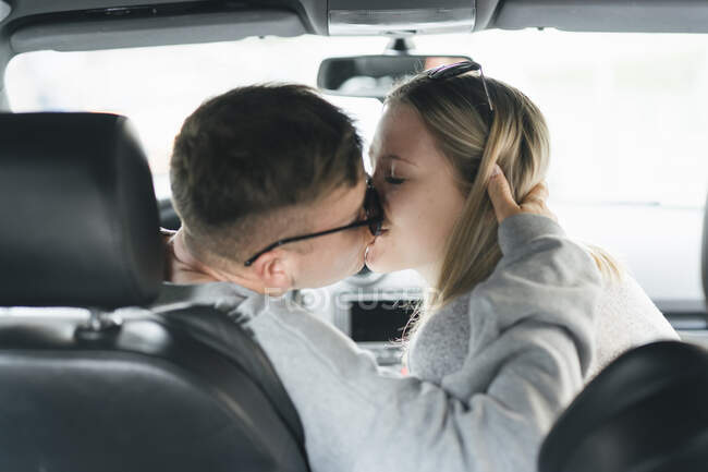 Молода пара цілується в машині — стокове фото