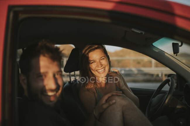 Щаслива пара під час подорожі, яка виглядала з вікна машини. — стокове фото