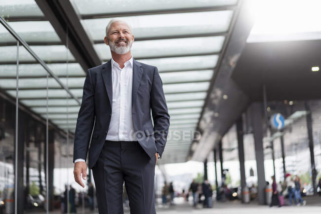 Sorridente uomo d'affari maturo in città in movimento — Foto stock