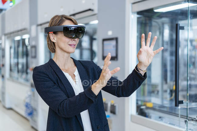 Бизнесмен в очках AR на современной фабрике — стоковое фото