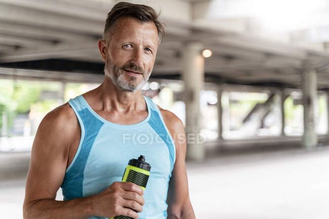 Uomo sportivo con bottiglia da bere — Foto stock