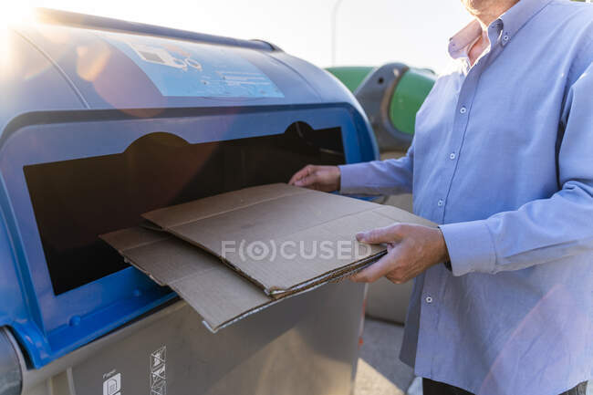 Hombre mayor reciclaje de cartón en banco de papel - foto de stock