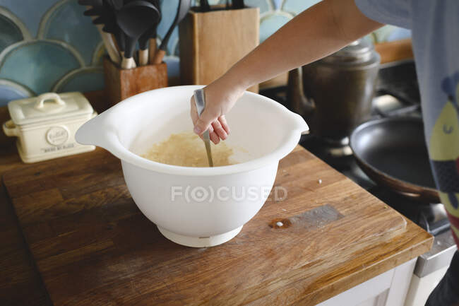 Mano del ragazzo mescolando pasta frittella in cucina — Foto stock