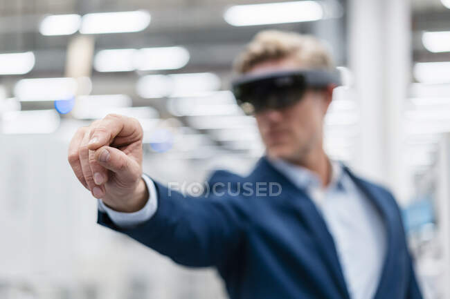 Empresario con gafas AR en una fábrica moderna - foto de stock
