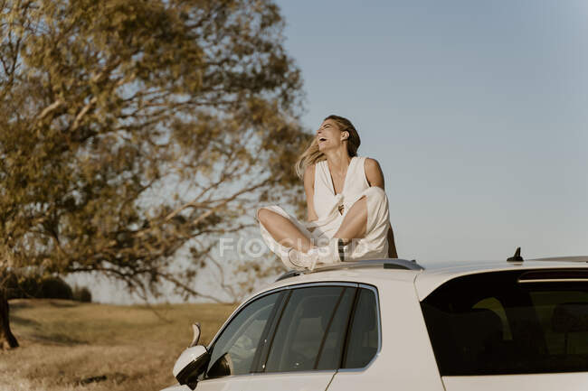 Lachende Reisende auf weißem Autodach — Stockfoto