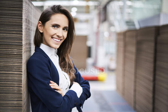 Retrato de empresaria sonriente en almacén de fábrica - foto de stock