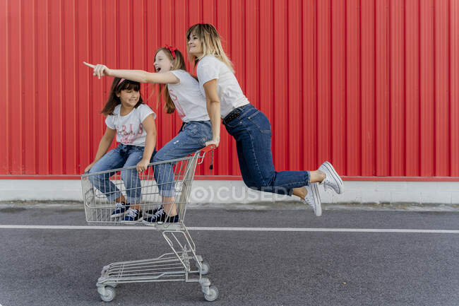 Мама зі своїми дітьми з кошиком для покупок. — стокове фото