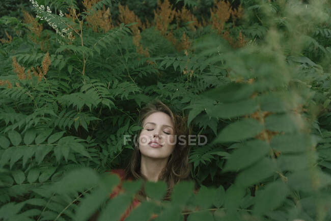 Visage de jeune femme au milieu des plantes — Photo de stock