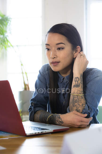 Woman using laptop at table in office — Stock Photo