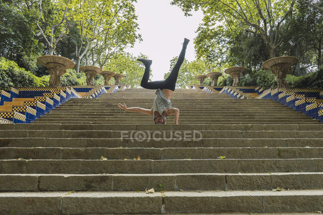 Young man doing acrobatics on stairs outdoors — Stock Photo
