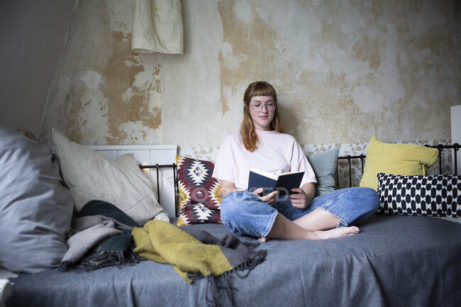 Studentessa che legge un libro nella sua stanza — Foto stock