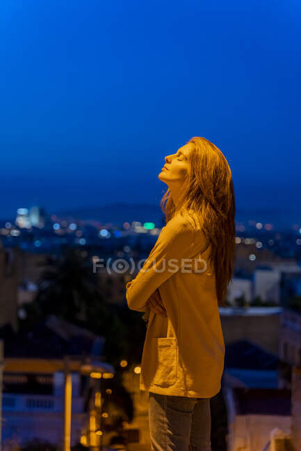 Giovane donna con gli occhi chiusi sul punto di vista all'ora blu — Foto stock