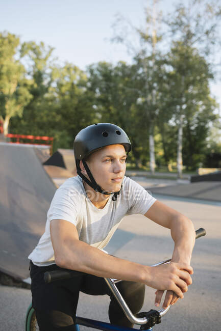 Jeune homme avec vélo BMX au skatepark faire une pause — Photo de stock