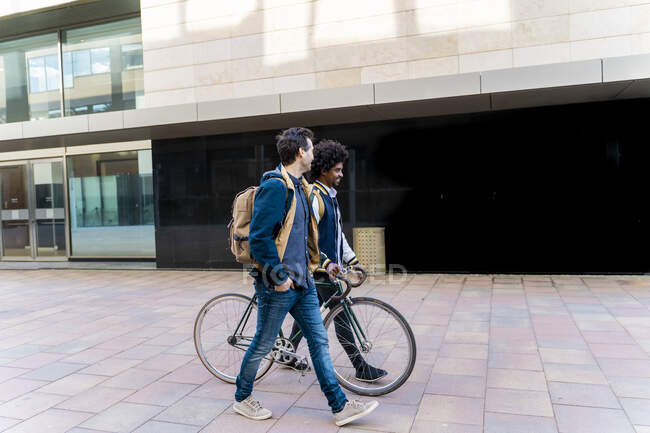 Два бізнесмени з велосипедами, які гуляють містом (Барселона, Іспанія). — стокове фото