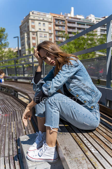 Giovane donna seduta su una panchina a Barcellona — Foto stock