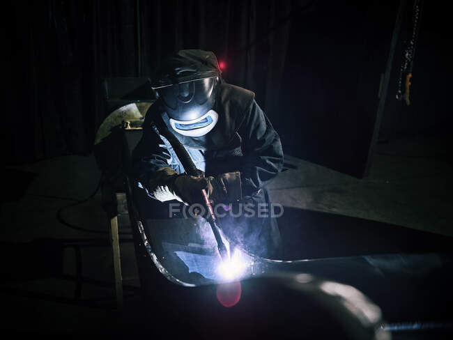 Промисловий працівник в захисному одязі зварювальний метал зі зварювальним факелом — стокове фото