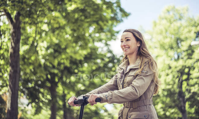 Portrait of smiling woman riding E-Scooter — Stock Photo