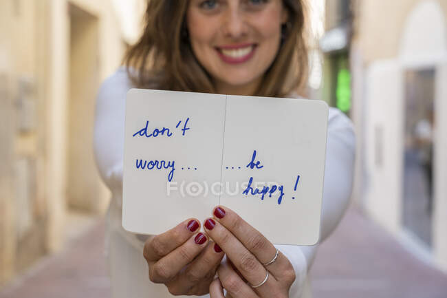 Портрет улыбающейся женщины, держащей в руках блокнот: Не волнуйтесь, будьте счастливы! — стоковое фото