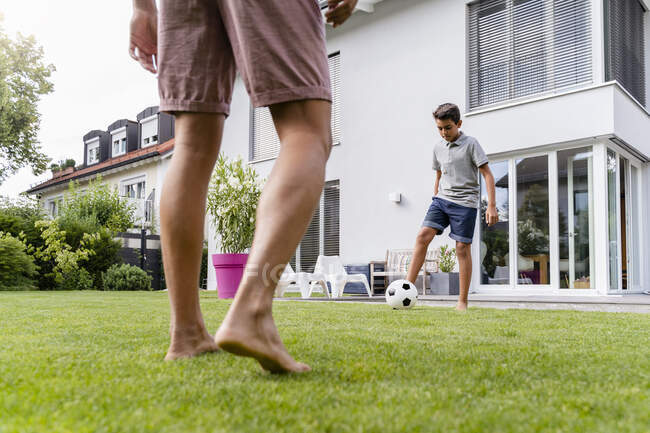 Father and son playing football in garden — Stock Photo