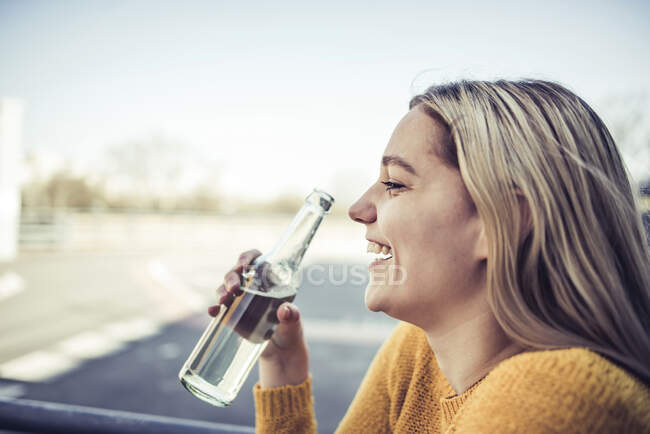 Profilo di laughing giovane donna con soft drink — Foto stock