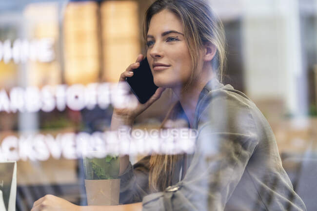 Junge Geschäftsfrau in einem Café, aus dem Fenster gesehen — Stockfoto