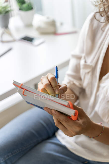 Gros plan de la femme prenant des notes au bureau à la maison — Photo de stock