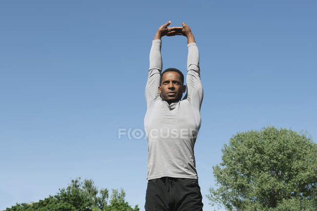 Esportista esticando os braços — Fotografia de Stock