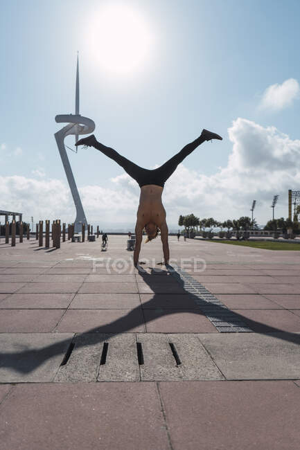 Jeune homme faisant un handstand dans le rétroéclairage — Photo de stock