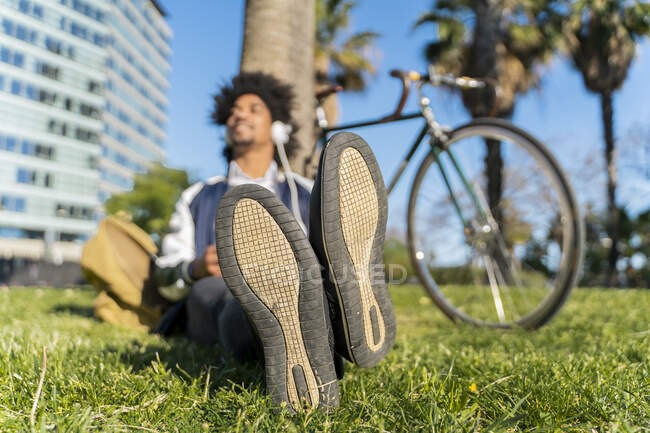 Homem de negócios casual fazendo uma pausa no parque urbano ouvindo música, Barcelona, Espanha — Fotografia de Stock